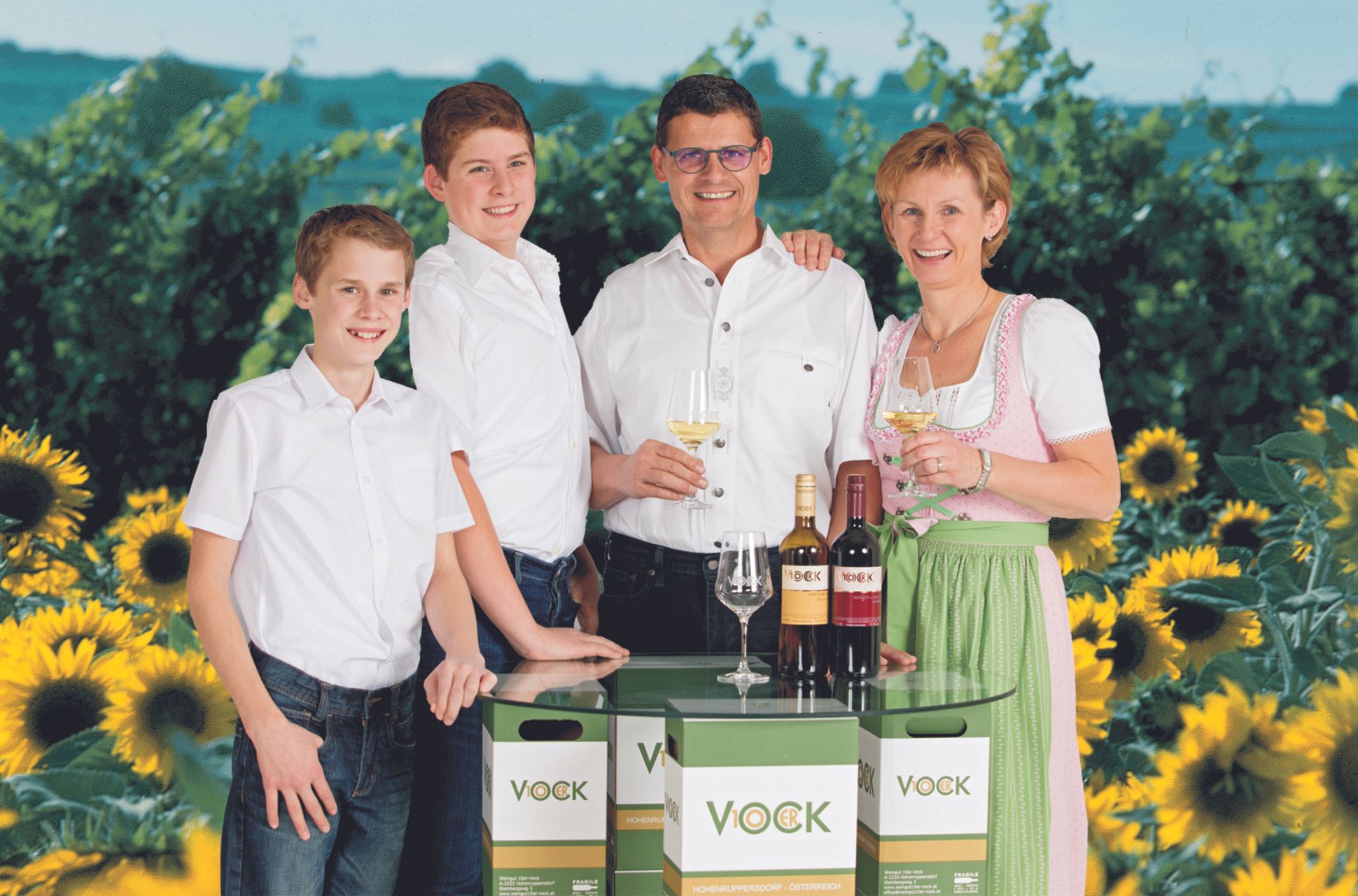 Family with wine bottles and sunflowers in the background.