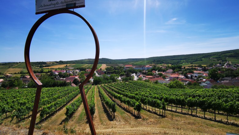 View of vineyards and village through a large keyhole symbol in Mailberg.