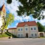 Zuschmann vicarage with church and blue sky.