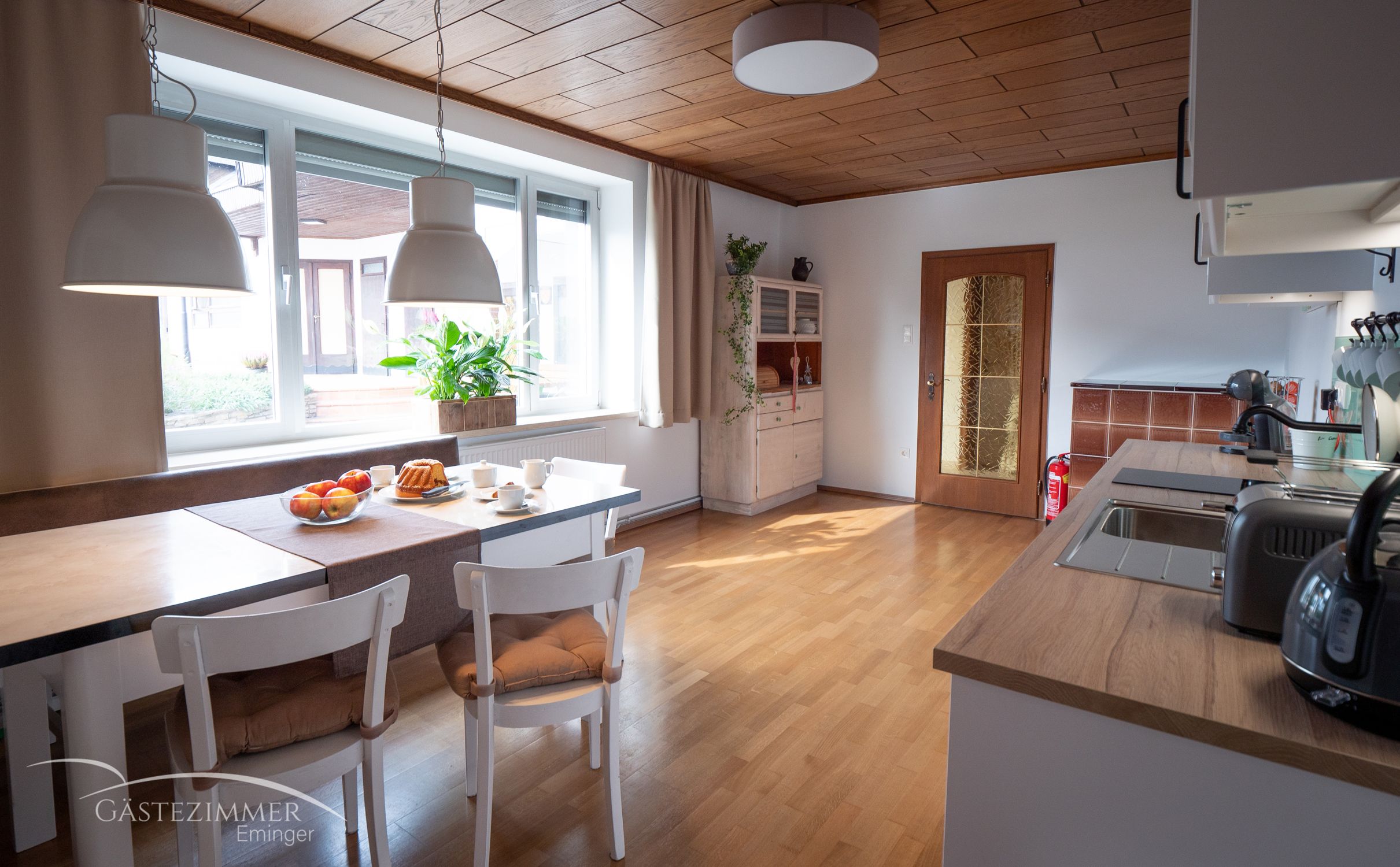 Moderne Wohnküche mit Esstisch, Stühlen und Küchenzeile.