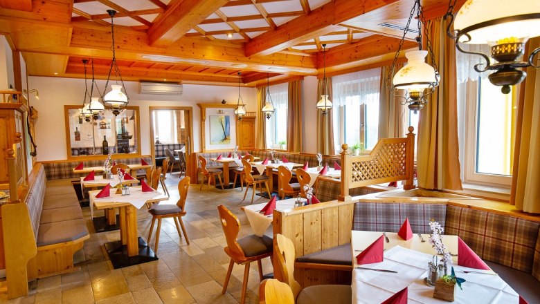 Gemütliches Restaurant mit Holzmöbeln und gedeckten Tischen.