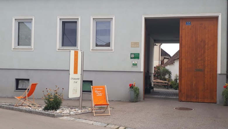 Weingut Krell, © Weingut Krell Eingang eines Weinguts mit Schild 'Krell', Liegestuhl und Pflanzen.