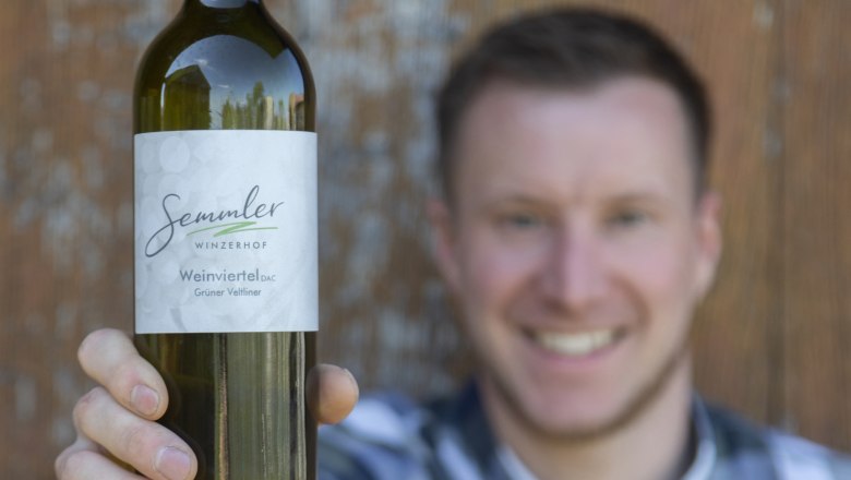 Ein Mann h&auml;lt eine Flasche Wein vom Winzerhof Semmler in die Kamera.