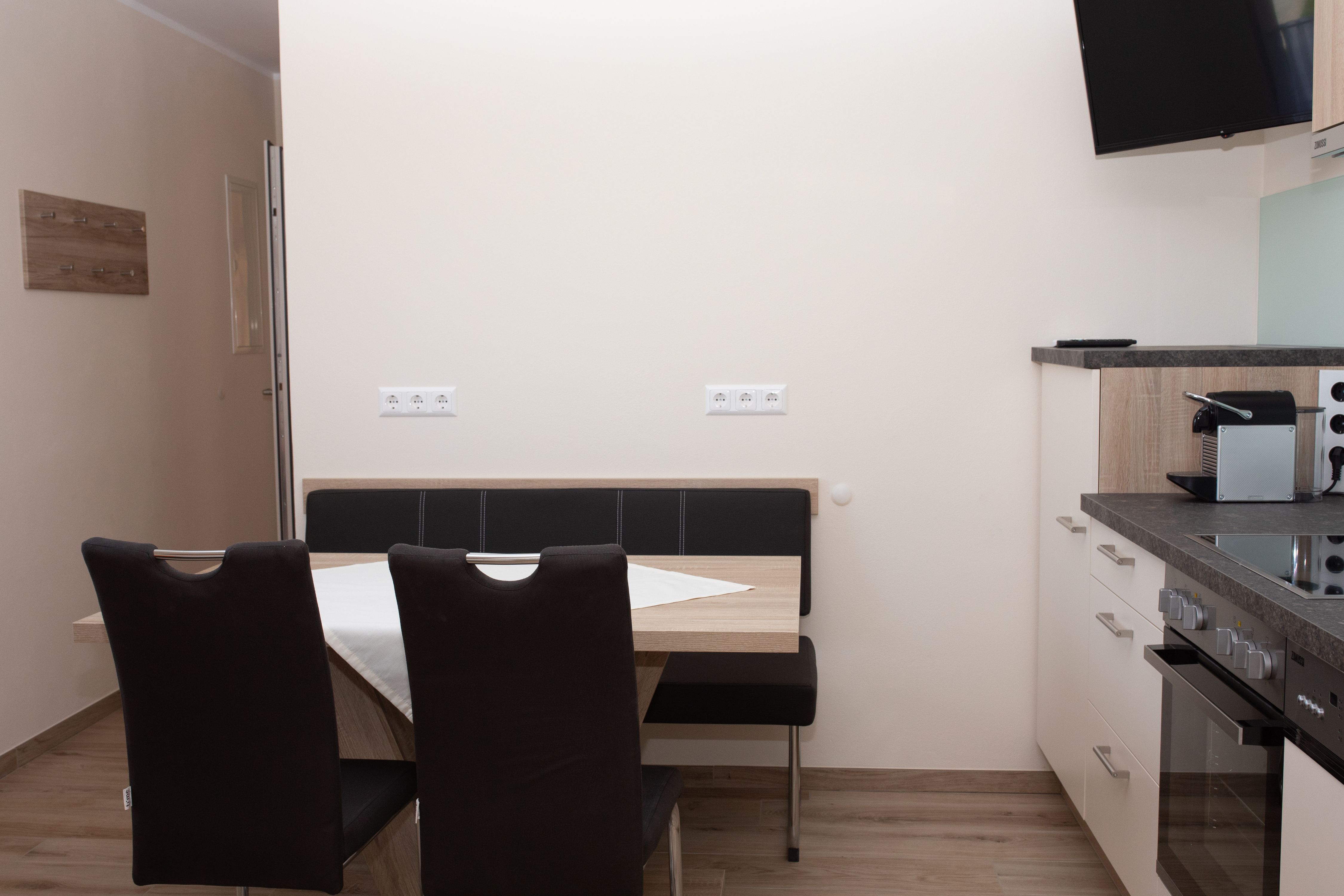 Essbereich mit Tisch, Stühlen und Küchenzeile.