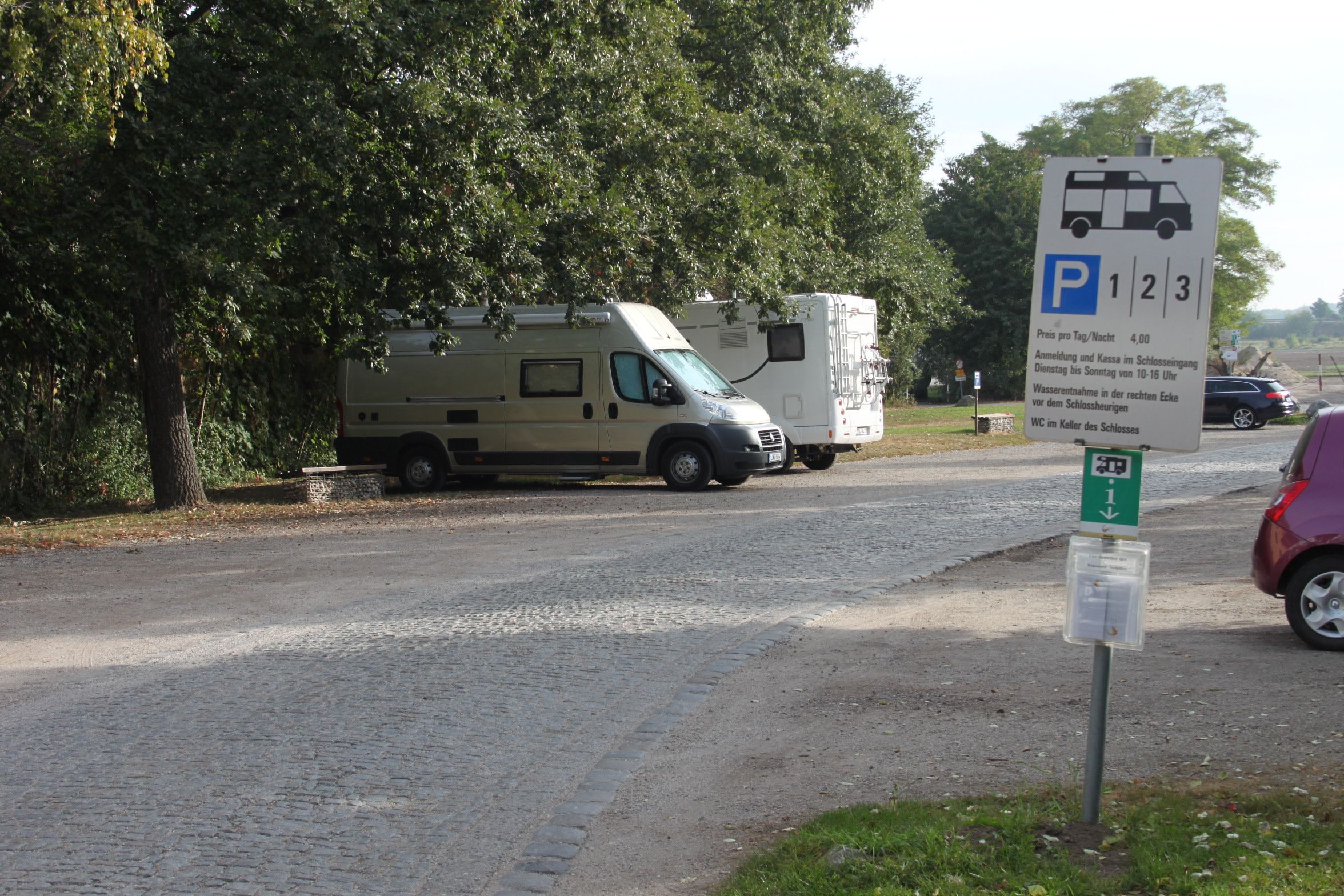 Parkovisko pre obytné vozidlá s dvoma zaparkovanými obytnými vozidlami a ukazovateľom.