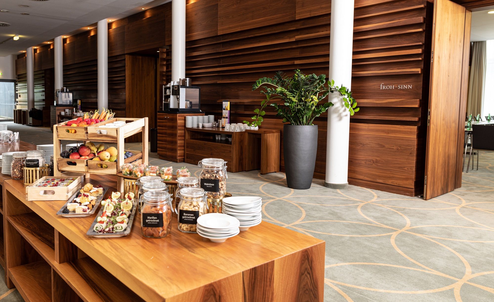 Buffet mit Snacks und Getränken in einem modernen Seminarraum.