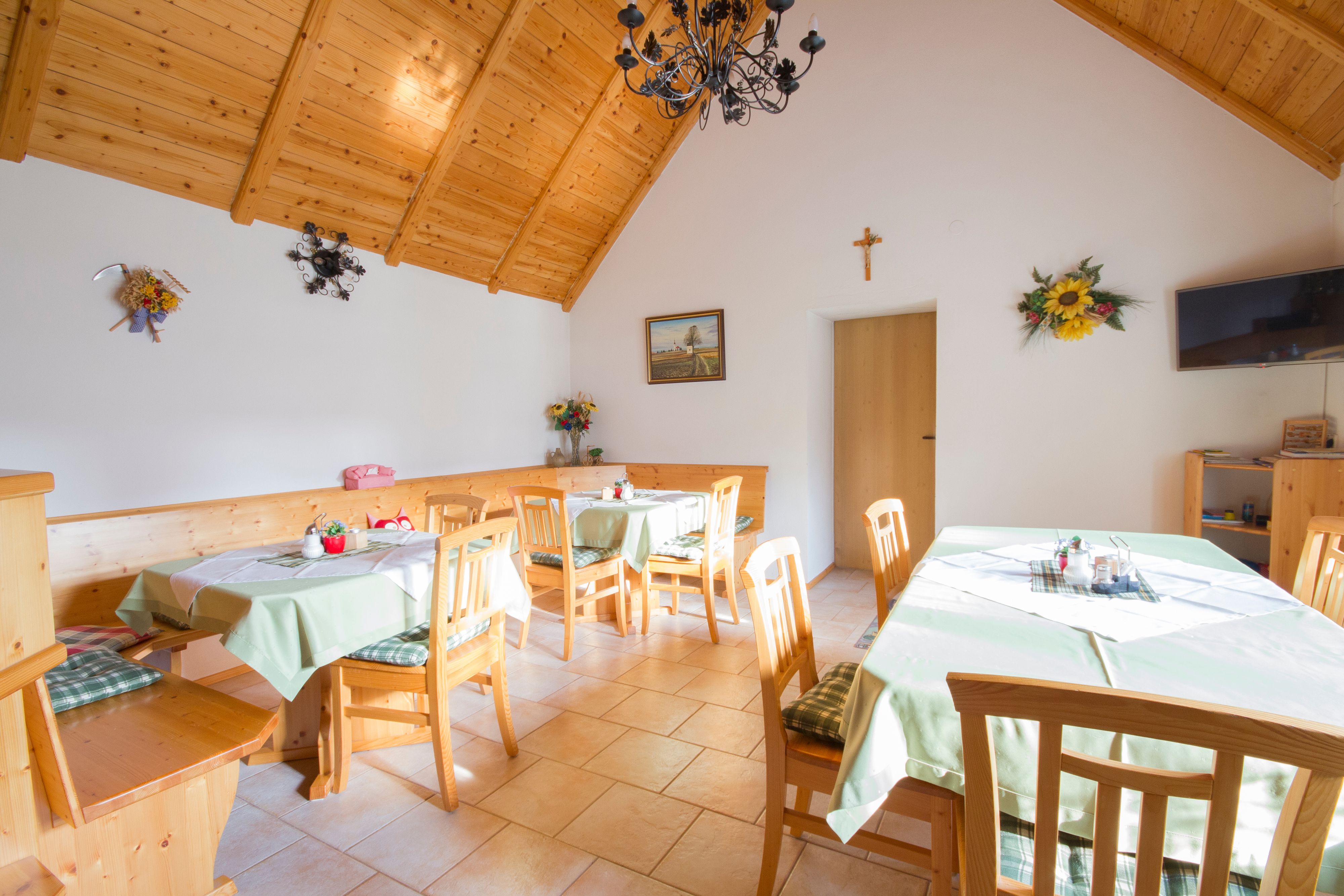 Gemütlicher Raum mit Holzmöbeln und dekorierten Tischen.