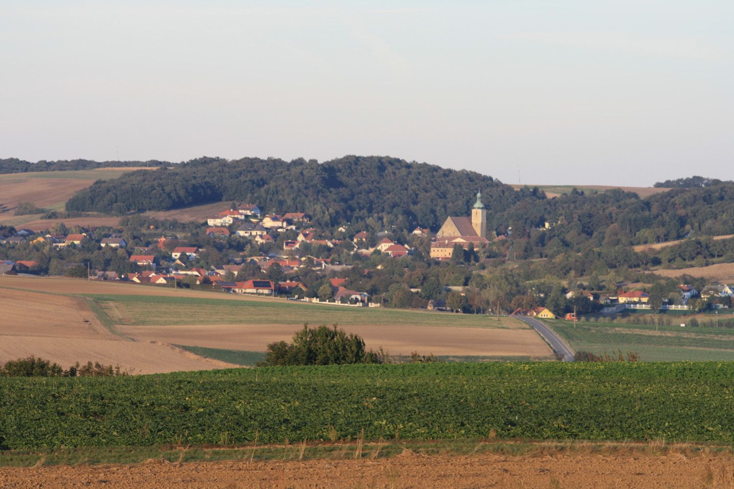 Panoramablick auf Großrußbach mit Kirche und umliegenden Feldern.