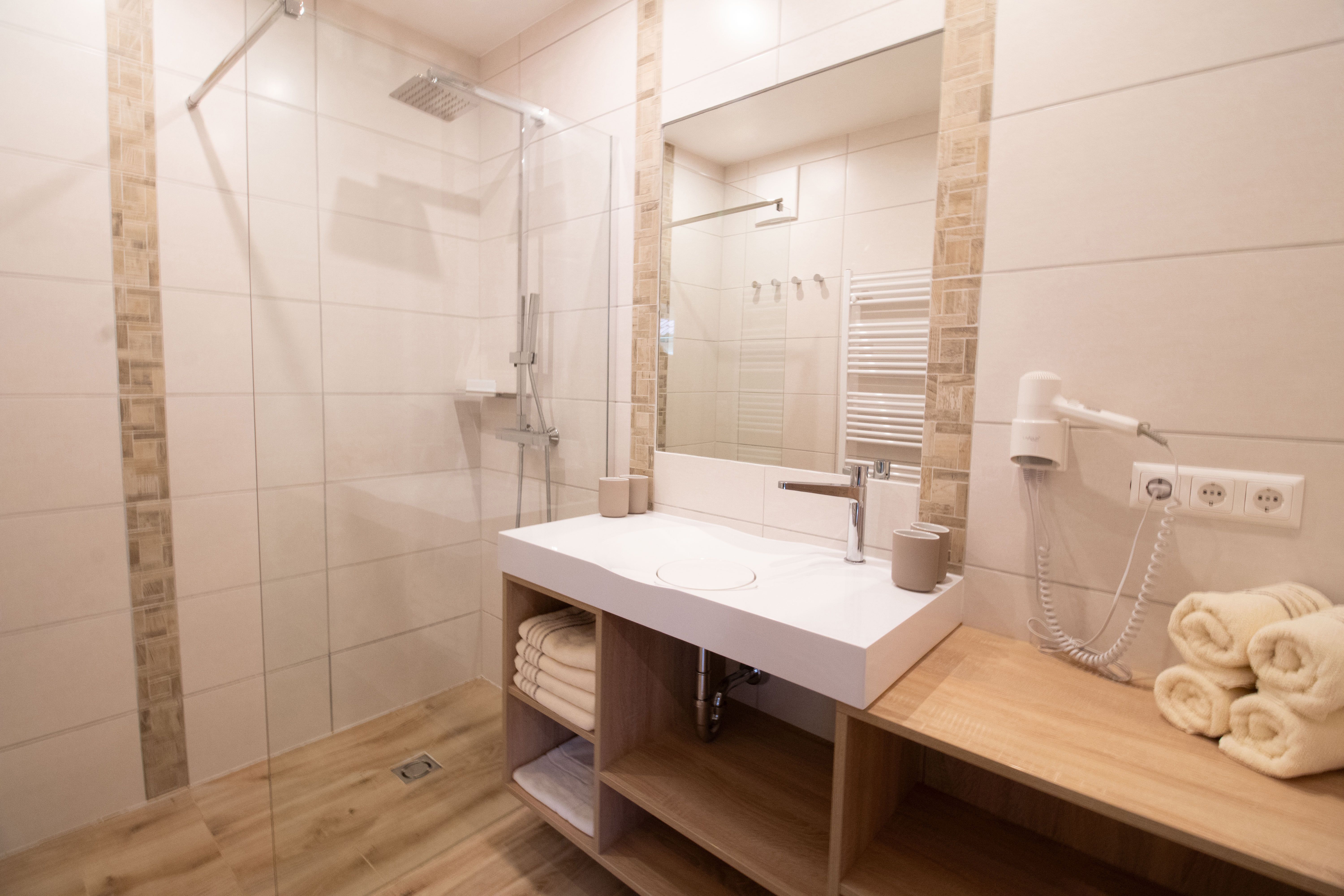 Modernes Badezimmer mit Dusche, Waschbecken und Handtüchern.