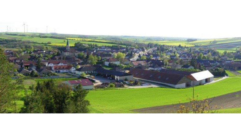 Landscape with village and church, surrounded by fields.