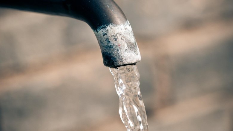 Nahaufnahme eines Wasserhahns mit flie&szlig;endem Wasser.