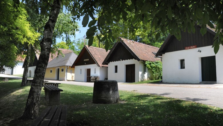 Eine malerische Kellergasse mit traditionellen Weinkellern und grüner Umgebung in Zellerndorf.