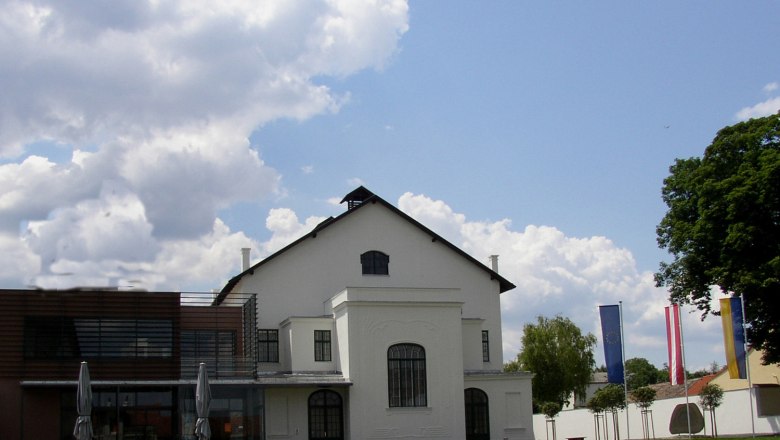 Konzerthaus Ziersdorf mit modernem Anbau und Flaggen im Vordergrund.