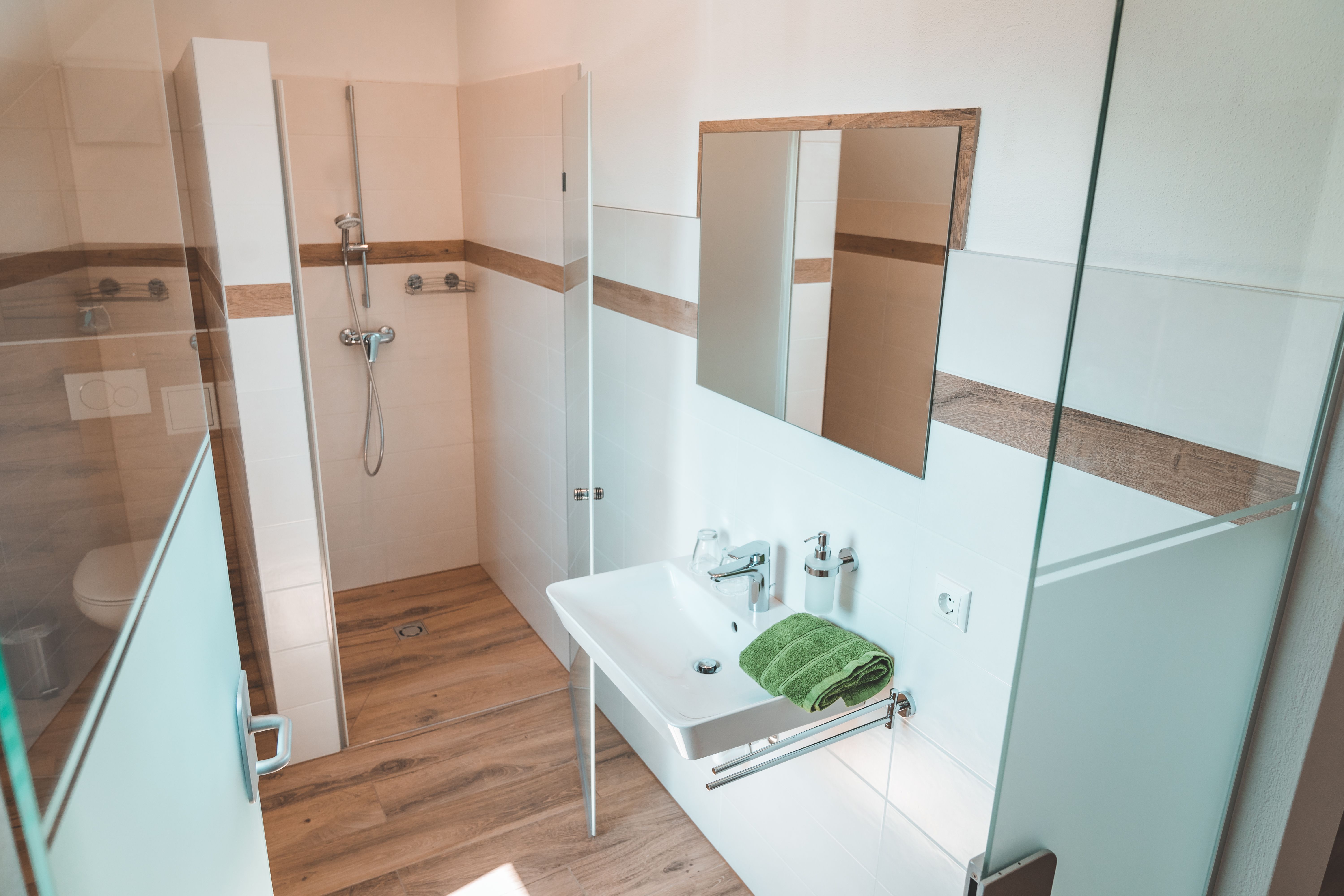 Modern bathroom with shower, washbasin and mirror.