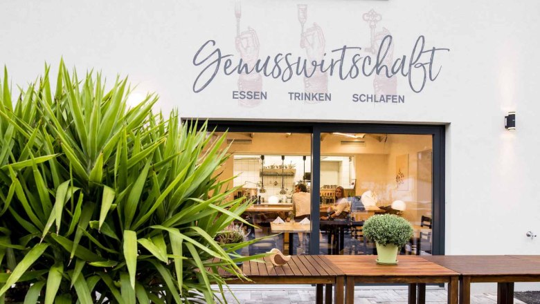 Au&szlig;enansicht eines Restaurants mit der Aufschrift 'Genusswirtschaft'.