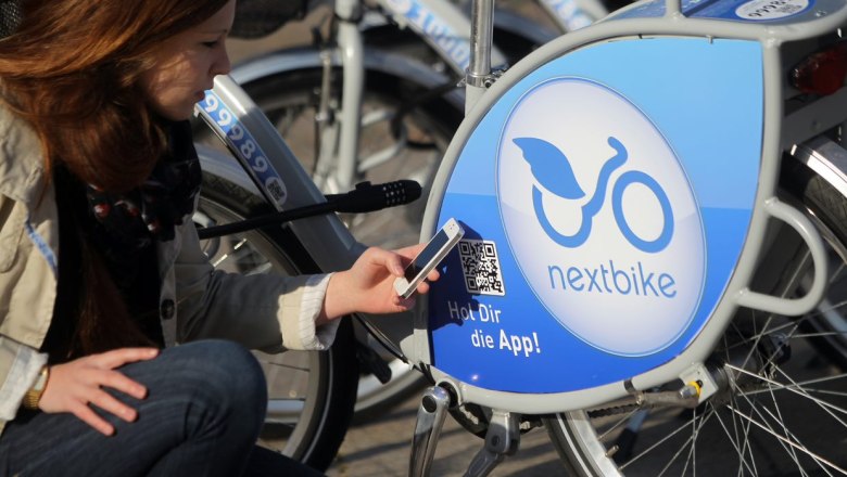 Frau scannt QR-Code an einem Nextbike-Fahrrad mit ihrem Smartphone.