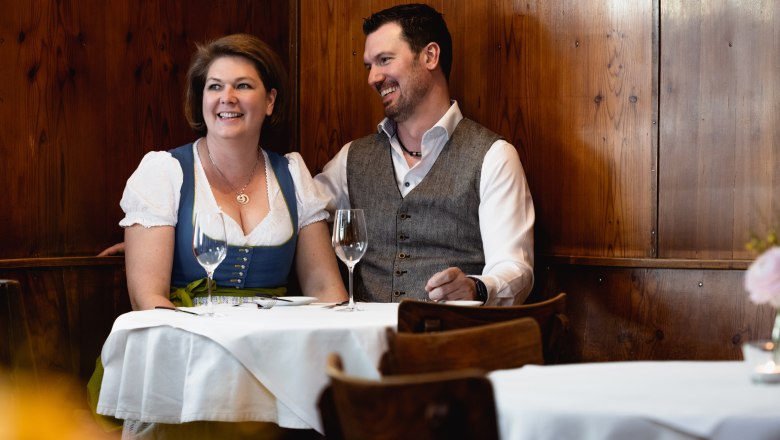 Smiling couple in traditional dress in a restaurant.