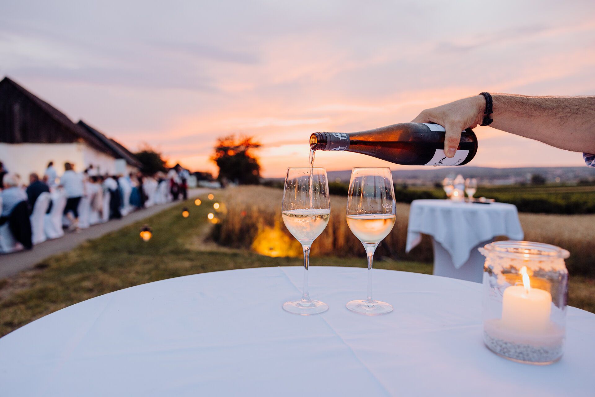 Ein romantischer Abend bricht an, während der Sonnenuntergang den Himmel in sanften Farben erleuchtet. Zwei Gläser prickelnder Sekt stehen bereit, um auf die genussvollen Momente des Lebens anzustoßen. Die Atmosphäre ist erfüllt von Vorfreude und der warmen Gastfreundschaft der Umgebung.