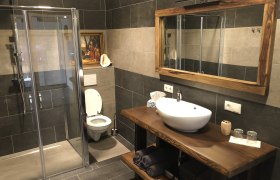 Modernes Badezimmer mit Dusche, Toilette und Waschbecken.