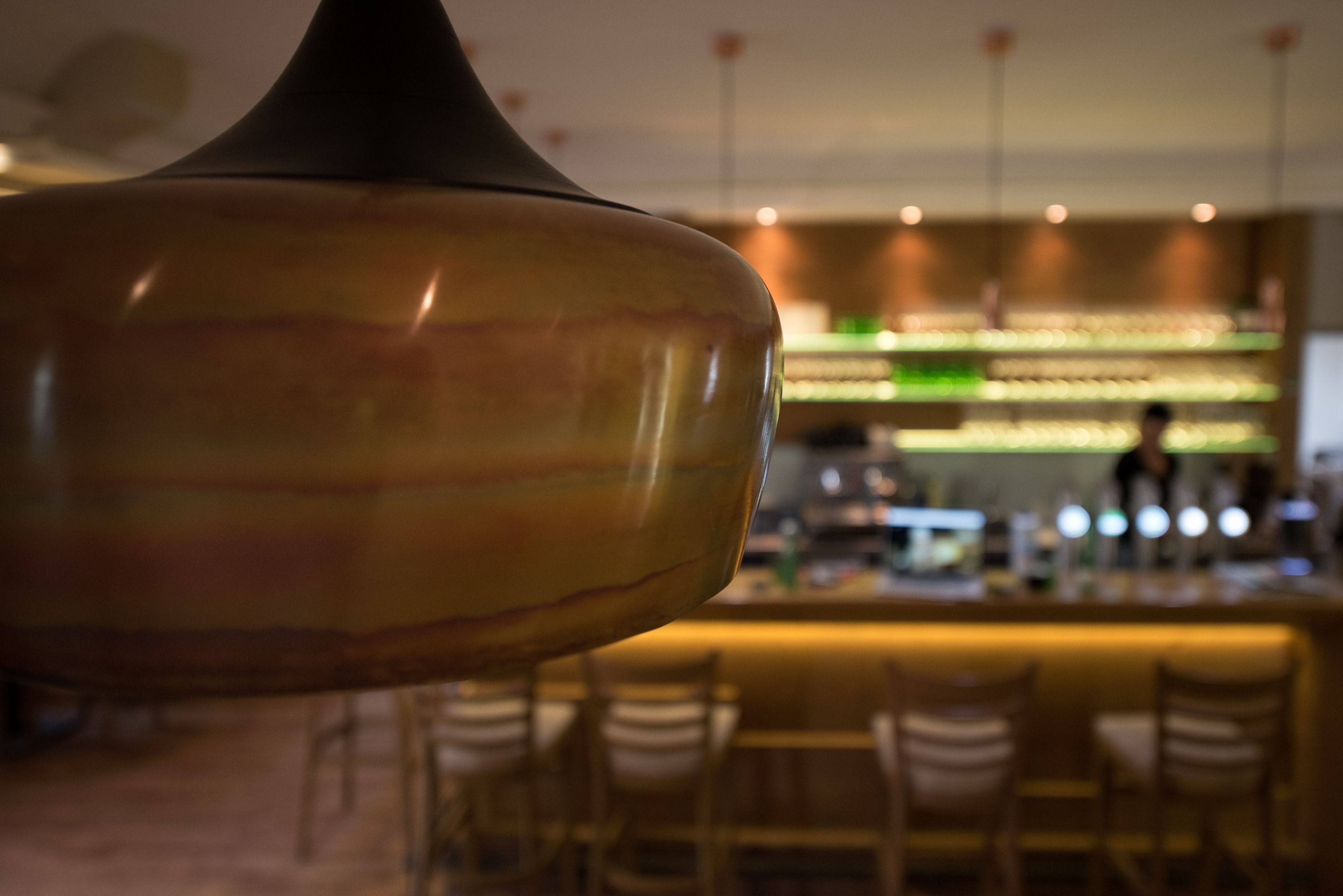 Close-up of a lamp in a stylish café with a bar in the background.