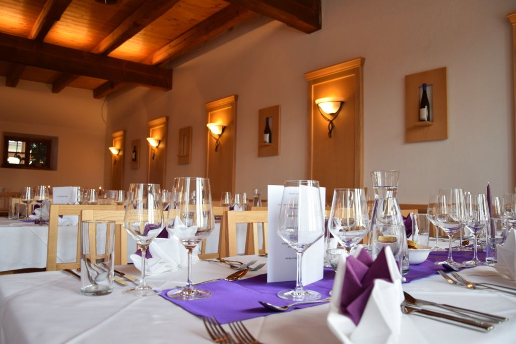 Elegant restaurant with laid tables, wine glasses and purple napkins.
