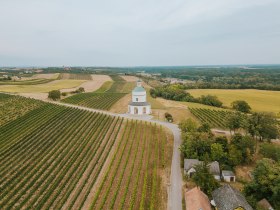 Sanfte H&uuml;gel und endlose Weinreben umarmen die malerische Landschaft, w&auml;hrend die charmante Kellergasse einladend zur Erkundung einl&auml;dt. Hier, wo die Natur und die Tradition des Weinbaus harmonisch verschmelzen, sp&uuml;rt man die Ruhe und den Zauber der Region.