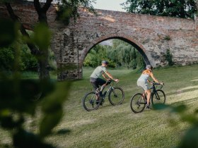 Ein Mann und eine Frau radeln entlang des Viadukts der ehemaligen Stadtmauer