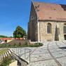 Stone staircase leads to a historic building with a red tiled roof and Gothic windows.