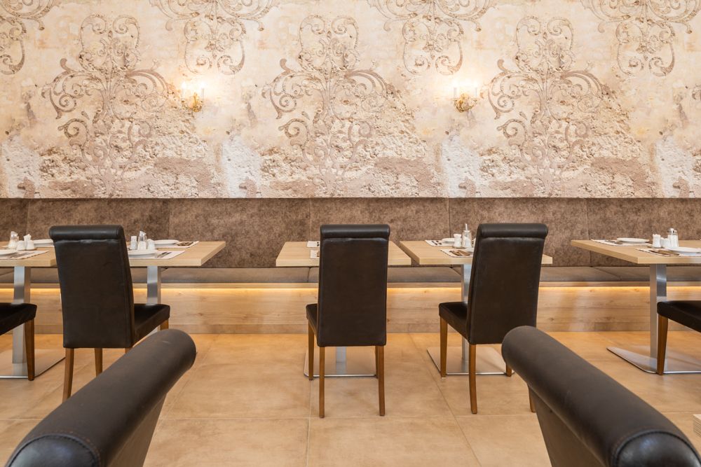 Ein elegantes Restaurant mit gedeckten Tischen und stilvoller Wanddekoration.