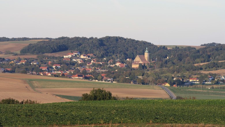 Panoramablick auf Großrußbach mit Kirche und umliegenden Feldern.