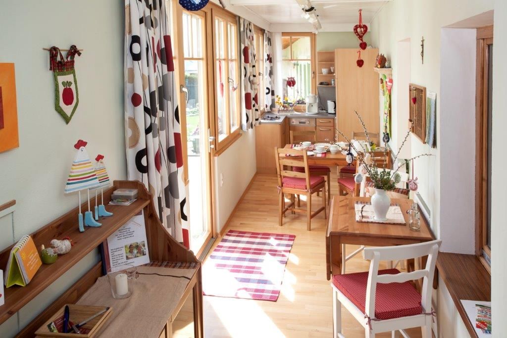 Gemütliche Ferienwohnung mit Holzmöbeln, Esstisch und dekorativen Vorhängen.