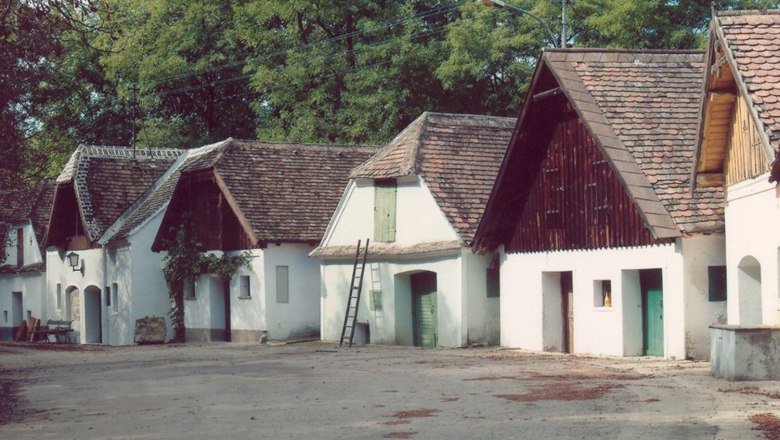 Traditional wine cellars with white facades and tiled roofs in a quiet location.
