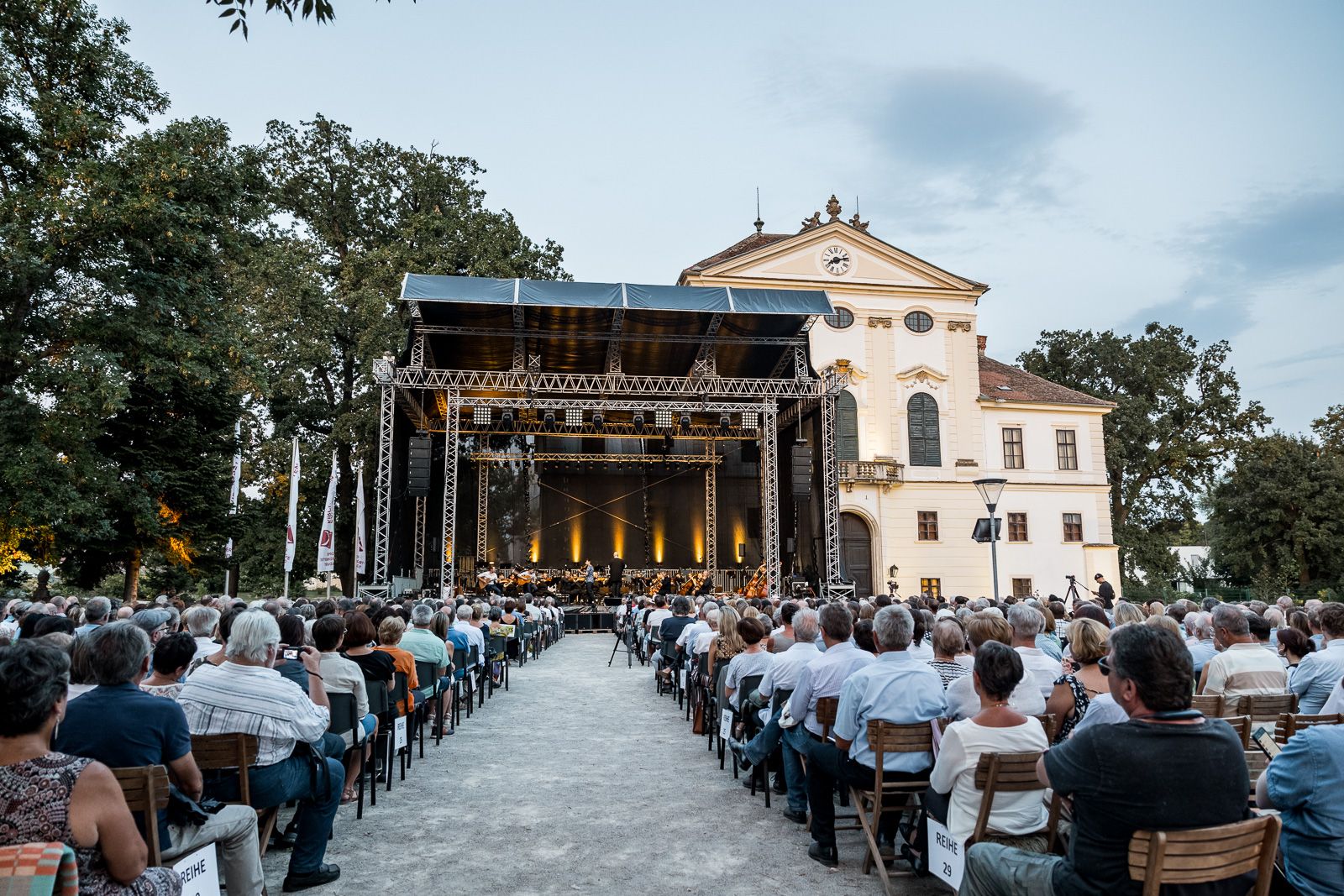 Konzert vor der malerischen Kulisse des Schloss Kirchstetten - Blick über die Zuschauer zur Bühne.