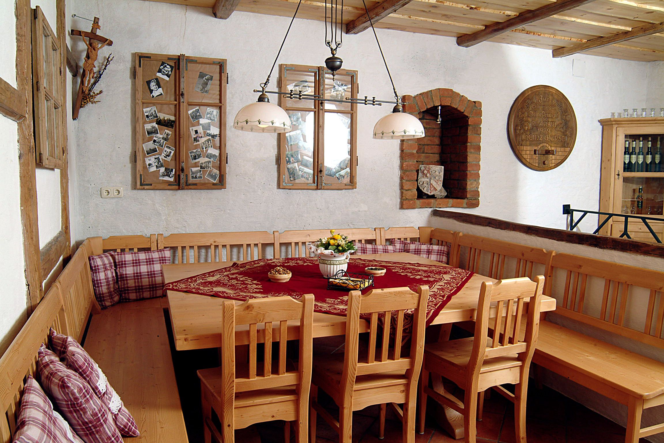 Gemütlicher Verkostungsraum mit Holzmöbeln, Tischdecke und Dekorationen an den Wänden.