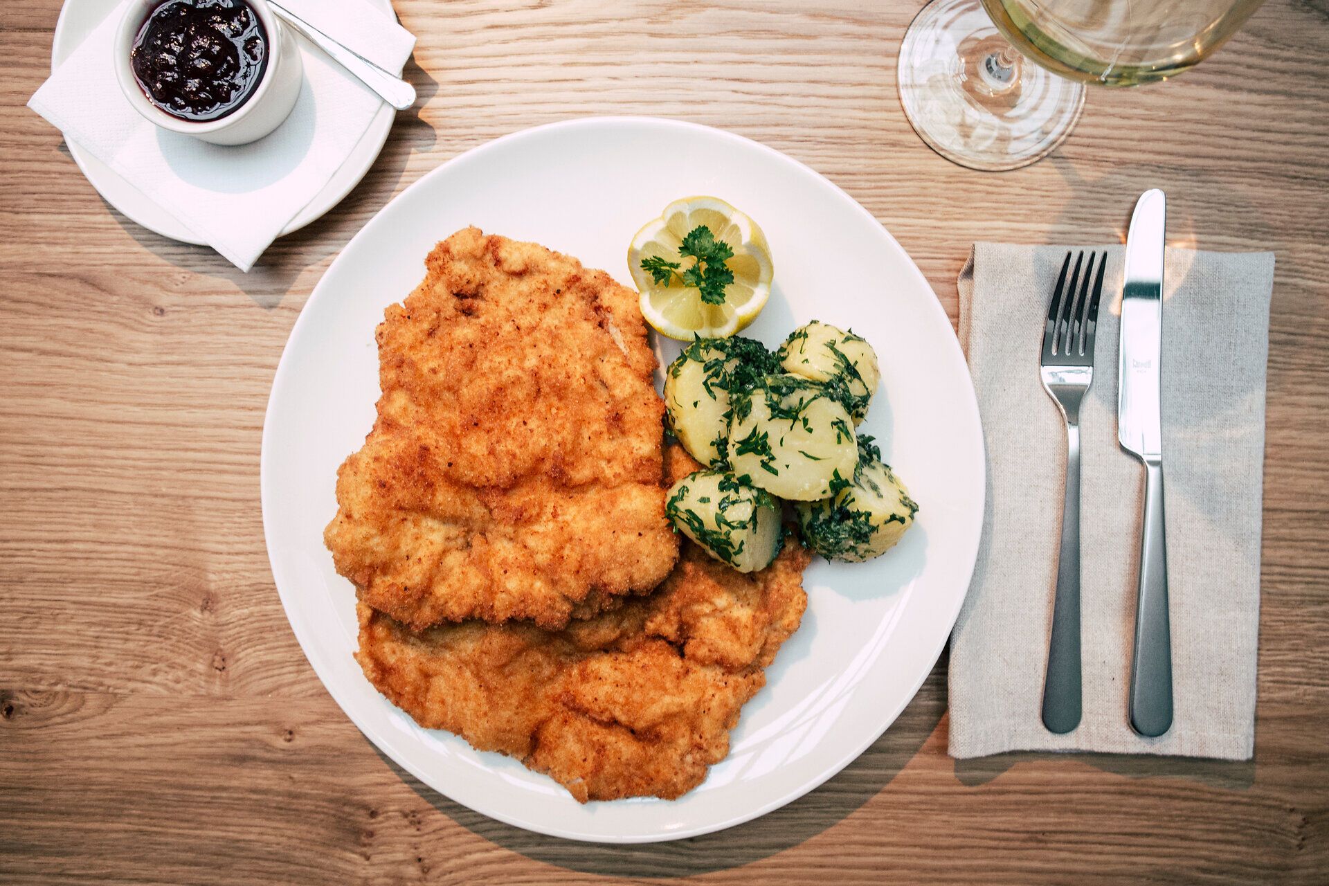 Genießen Sie ein köstliches Schnitzel, perfekt goldbraun gebraten, serviert mit frischen Petersilerdäpfeln und einer fruchtigen Preiselbeersauce. Diese traditionelle Speise lädt dazu ein, die herzliche Wirtshauskultur Niederösterreichs zu erleben und sich in einer gemütlichen Atmosphäre verwöhnen zu lassen.