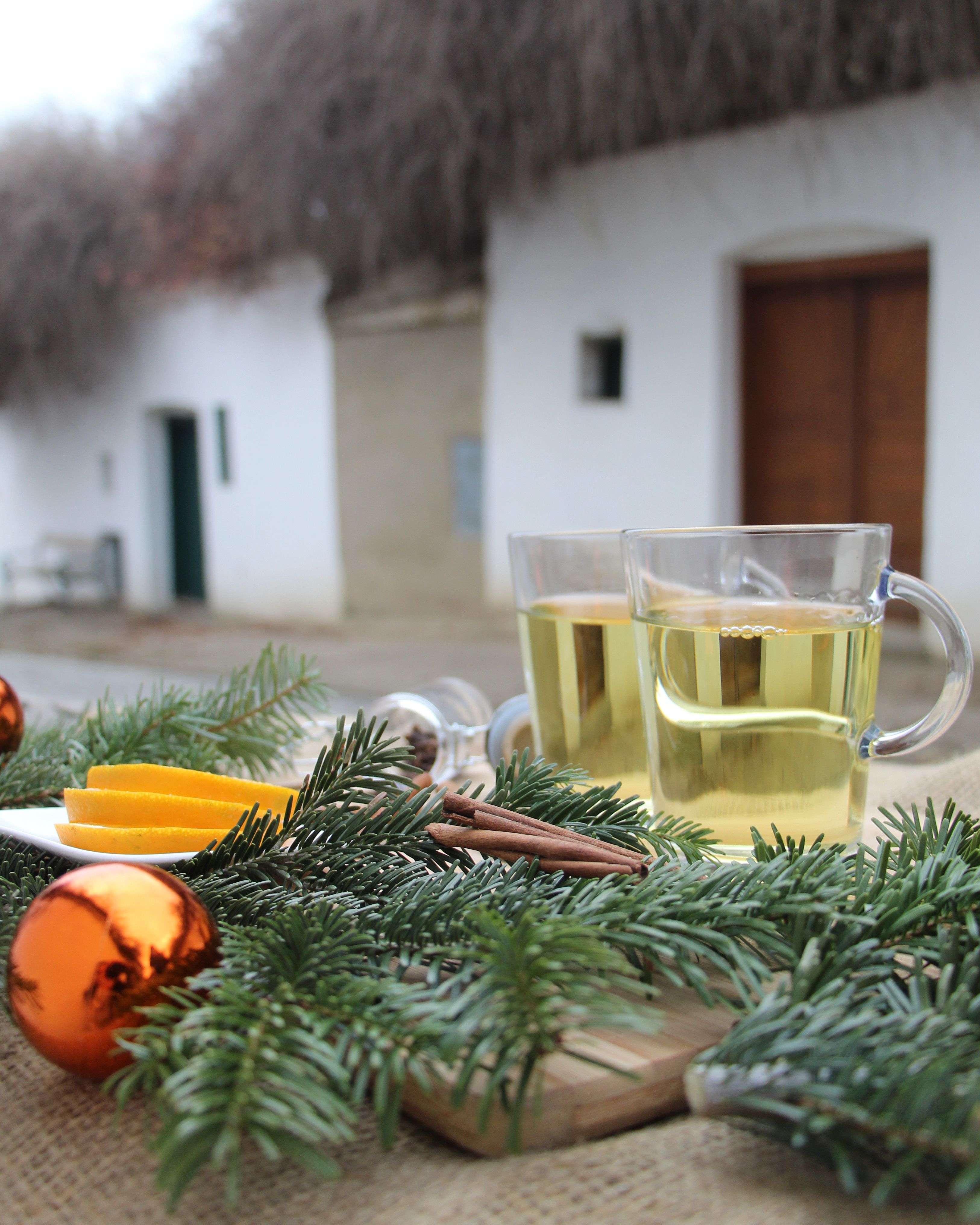 In einer Kellergasse stehen zwei Häferl mit Weinviertler Glühwein auf einem Stehtisch, welcher weihnachtlich dekoriert ist. 