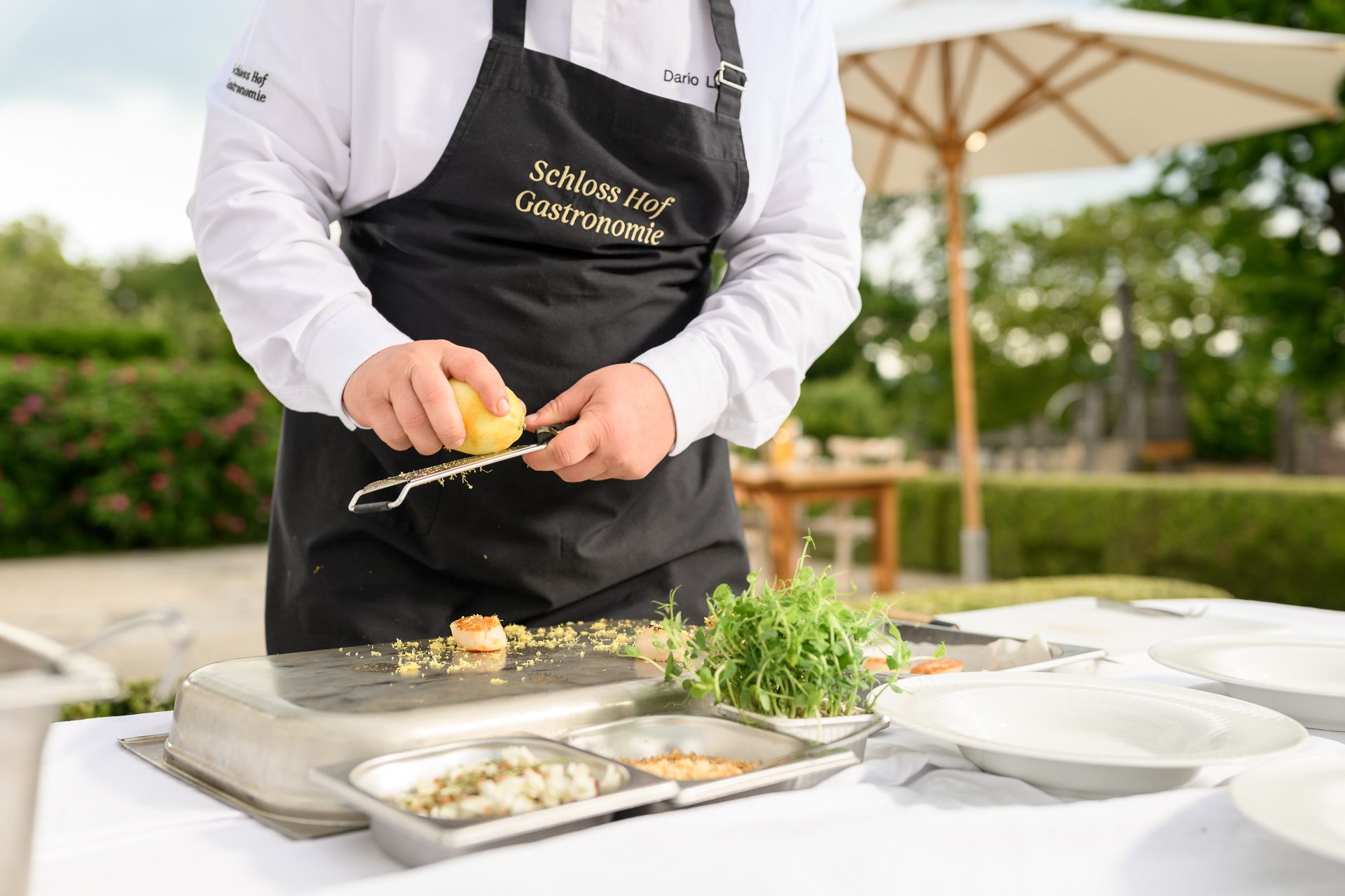 Koch reibt eine frische Zitrone über eine Garnele