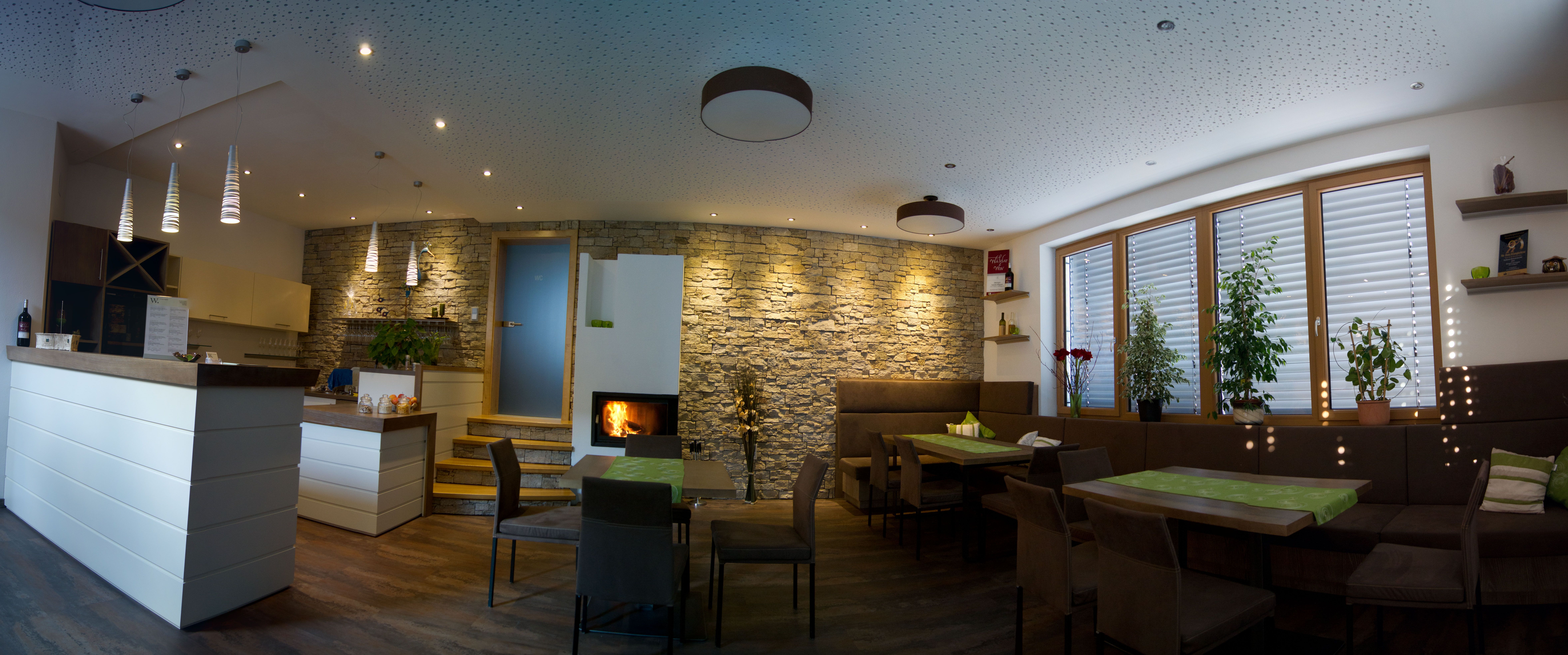 Moderní degustační místnost s barem, stoly a krbem.