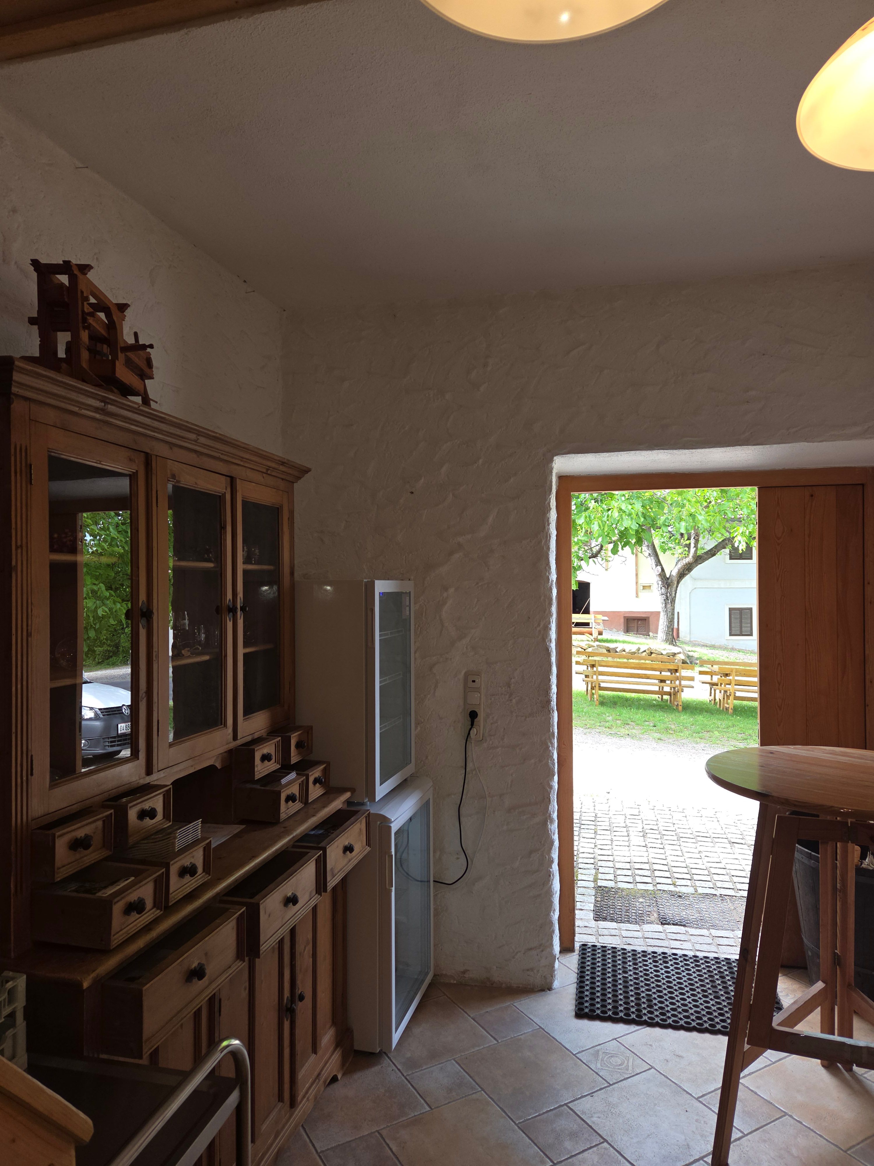 Interior with wooden furniture and view outside onto a terrace with benches.