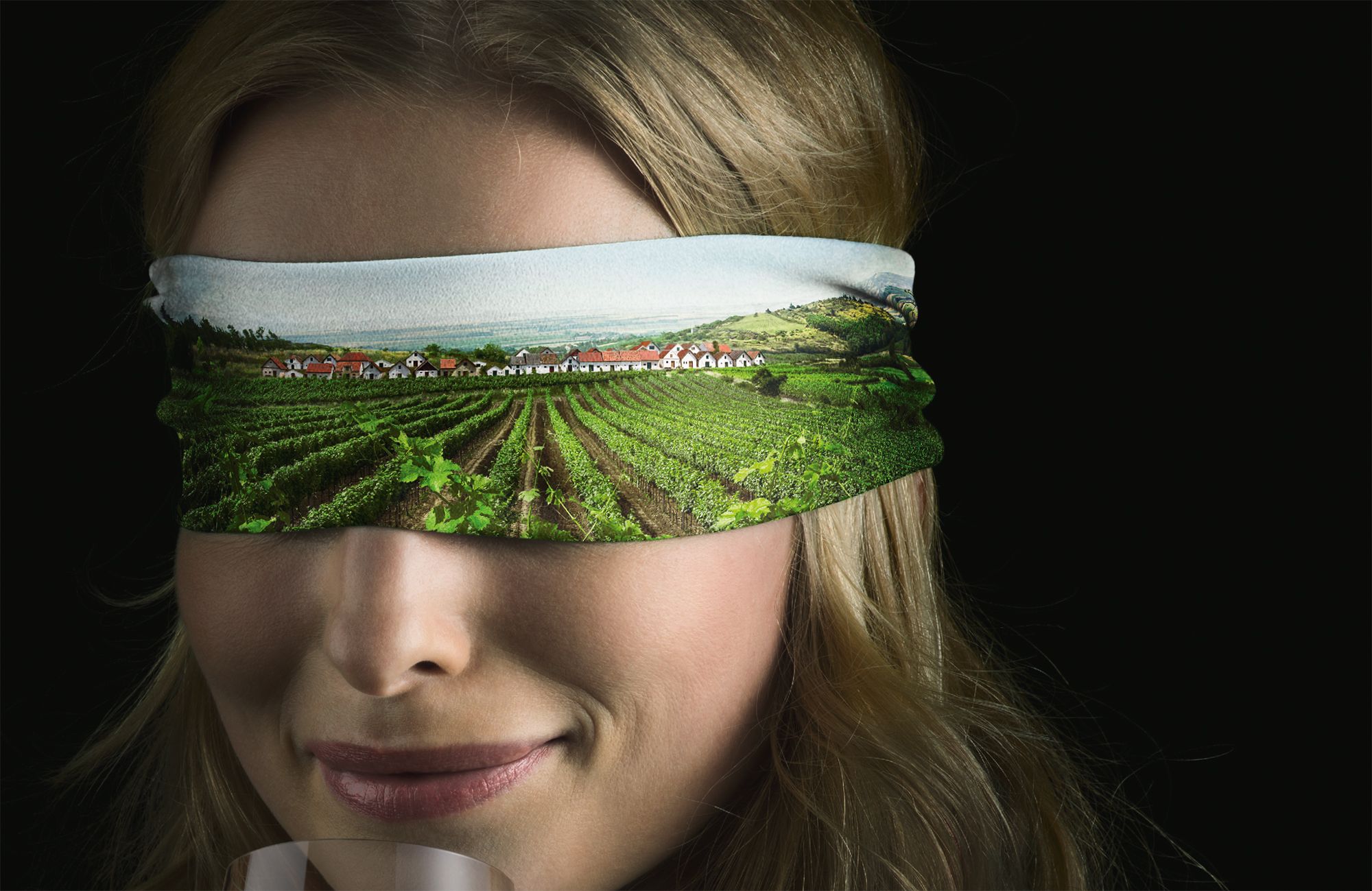Eine Frau mit verbundenen Augen verkostet Wein.