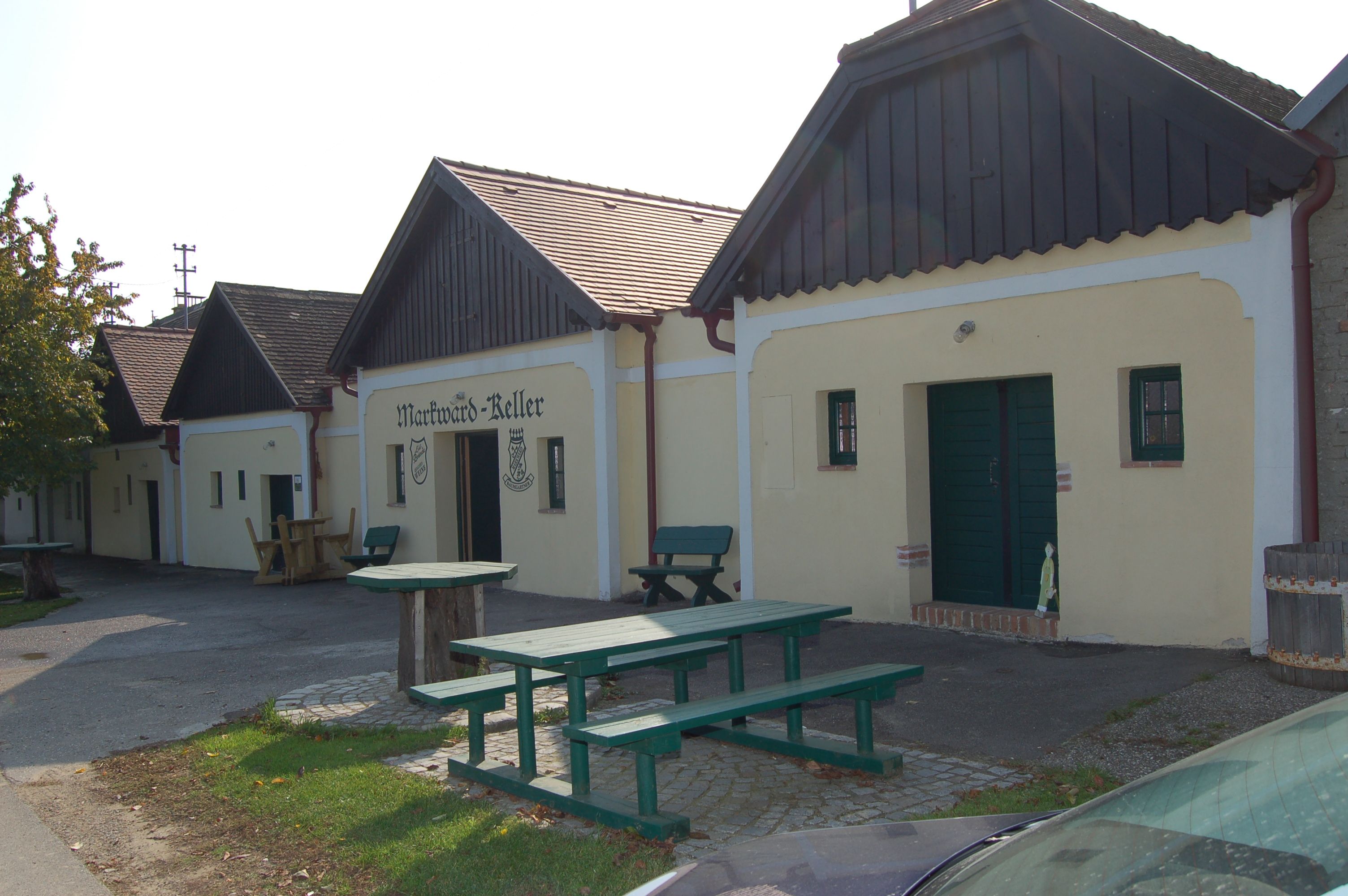 Exterior view of the Markward cellar with wooden benches and tables in front of it.