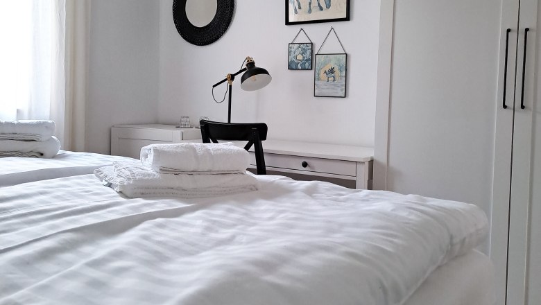 Rooms to feel good in, © Quartier35 Bright bedroom with double bed, desk and wall decoration.
