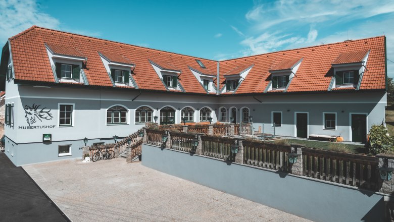 Ein Gebäude mit roten Dachziegeln und mehreren Dachfenstern, beschriftet mit 'Hubertushof'.