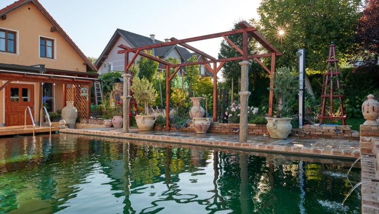 Ein mediterraner Garten mit Pool, Terrakotta-T&ouml;pfen und Holzkonstruktionen im Weinviertel.