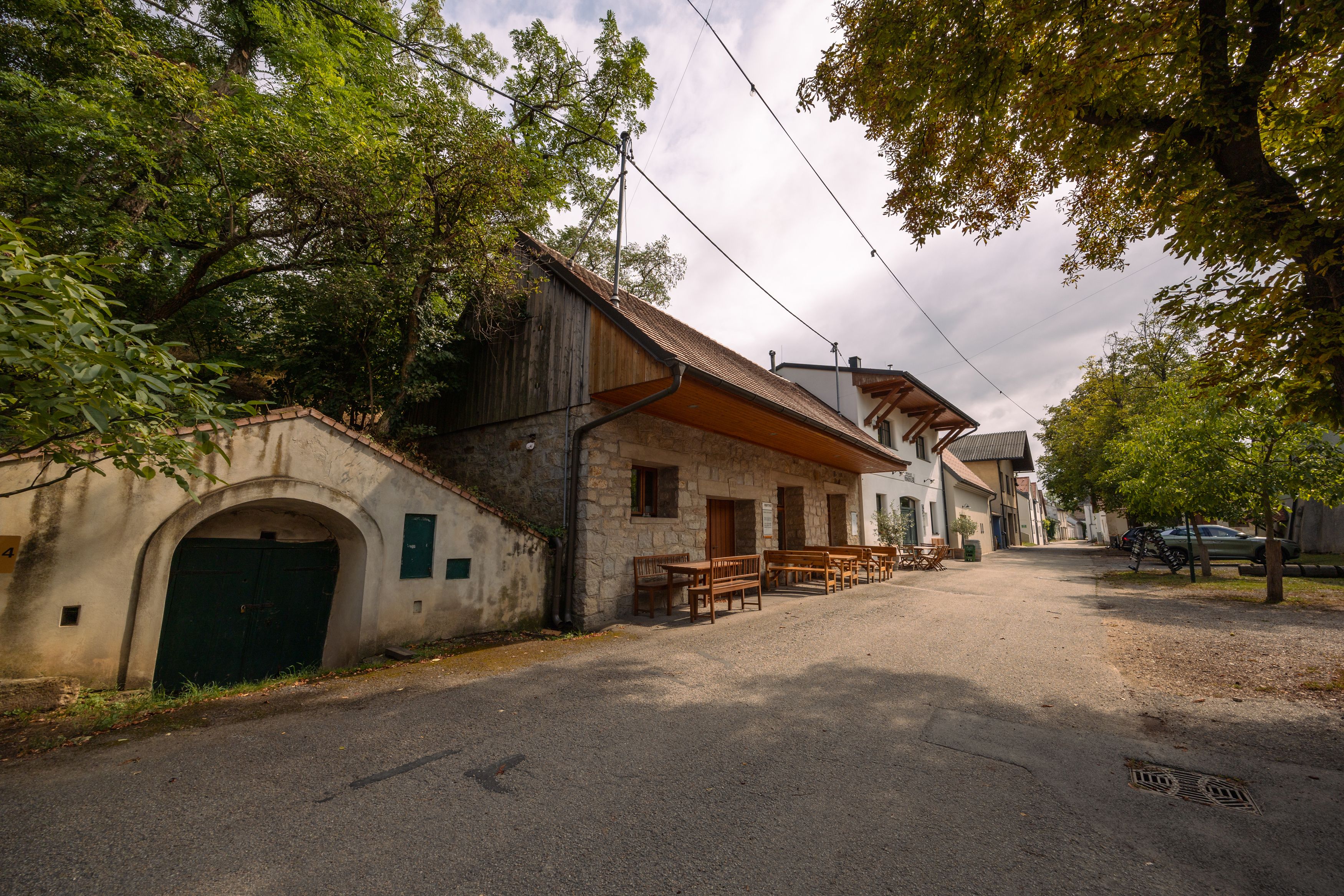 Weinviertler Kellerstöckl s rustikálními stavbami a stromy.