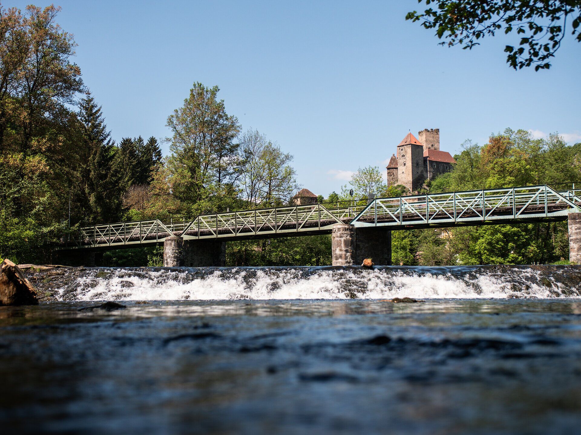 Die sanften Wellen des Flusses glitzern im Sonnenlicht, während die Thayabrücke majestätisch über das Wasser führt. Umgeben von üppigem Grün und dem sanften Rauschen der Bäume, lädt dieser Ort zum Verweilen und Entspannen ein.