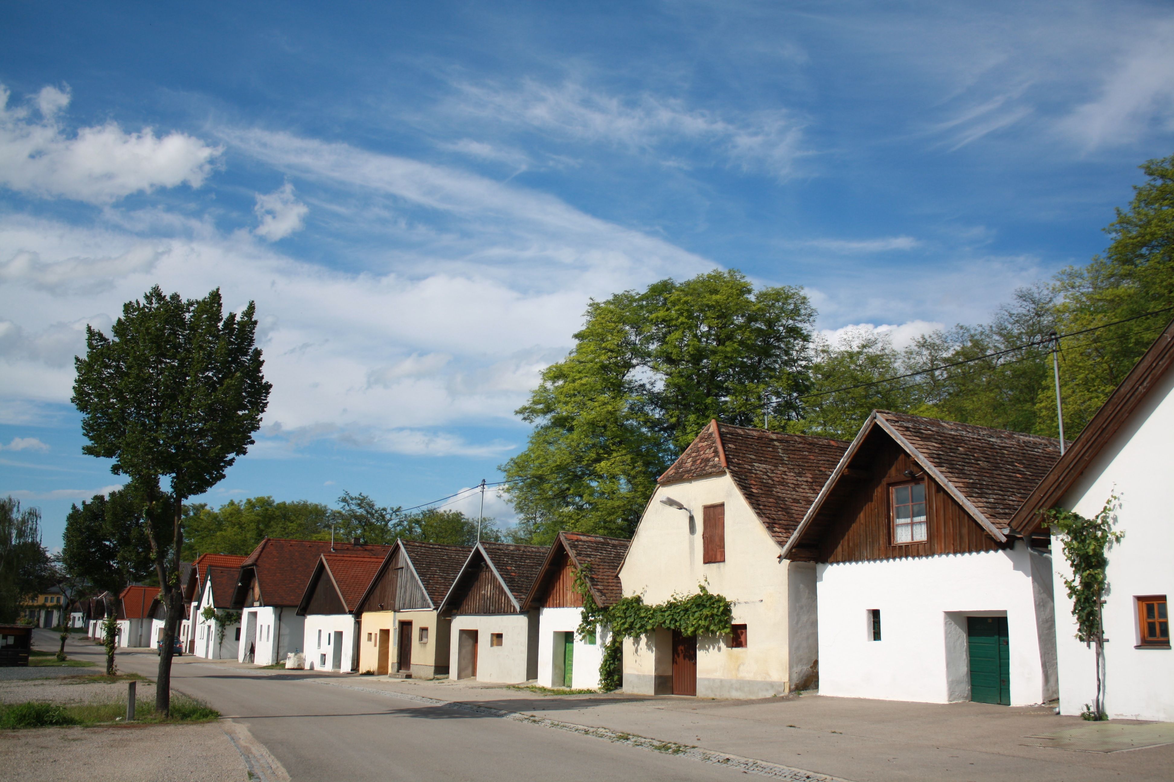 Reihe von traditionellen Weinkellern in Jetzelsdorf unter blauem Himmel.