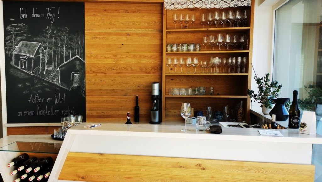 Tasting room with wooden counter, wine glasses and blackboard with drawing.