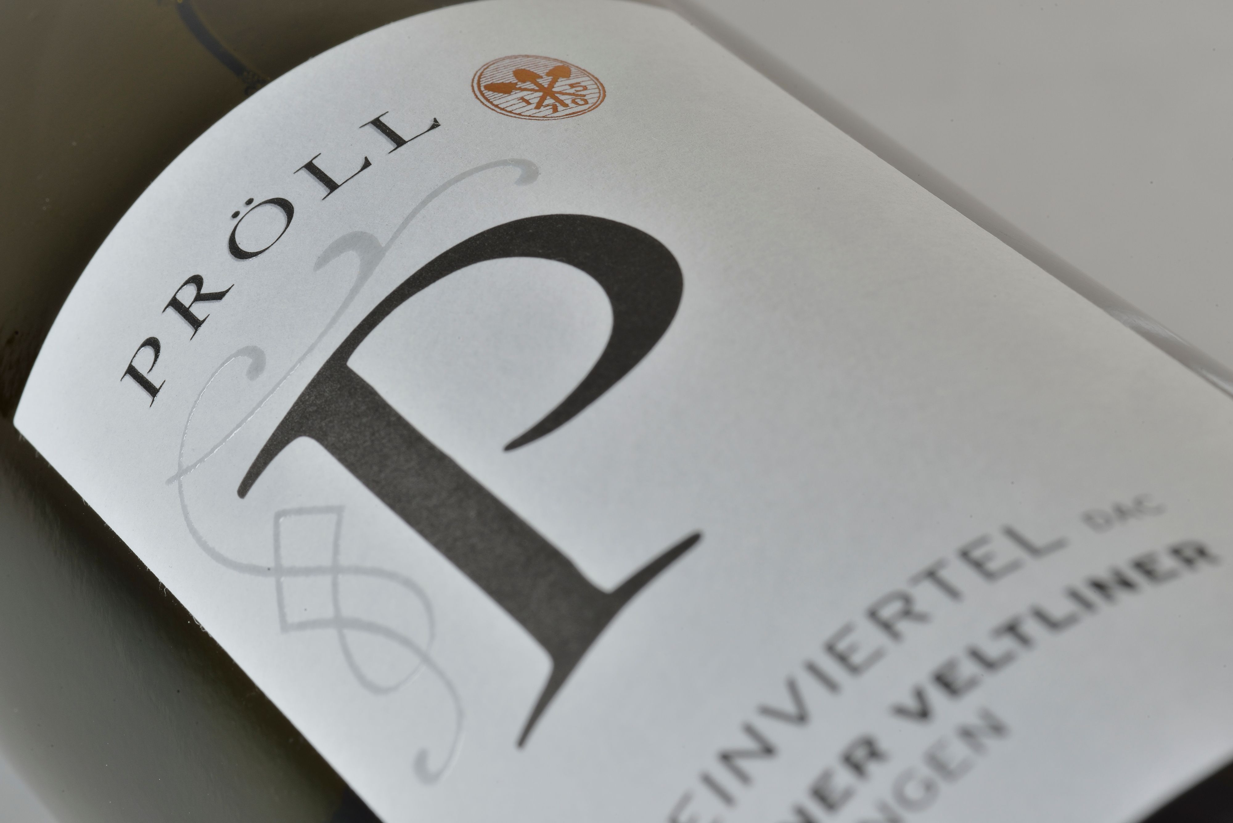 Nahaufnahme eines Weinetiketts mit der Aufschrift 'Pröll' und 'Weinviertel DAC Grüner Veltliner'.