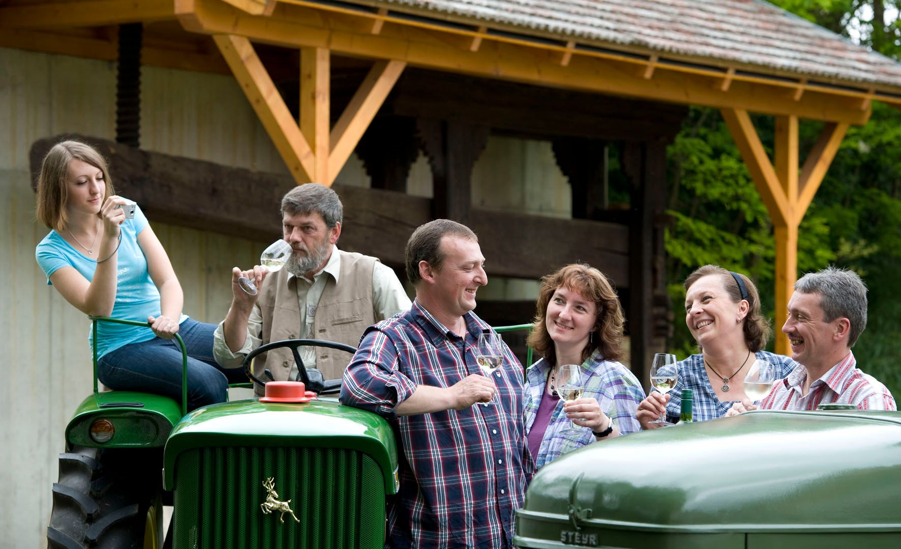 Group of people on a farm drinking wine.